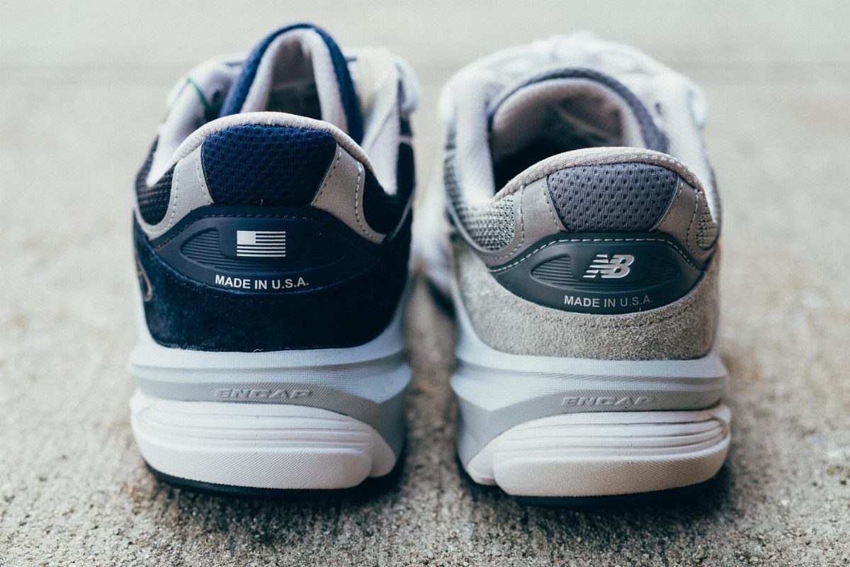 Two athletic sneakers, one navy and one grey, showing Made in USA markings on the heels.