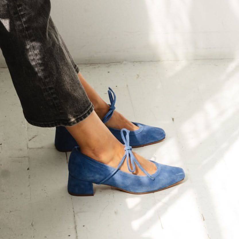 Blue velvet Mary Jane shoes with block heels worn with dark denim jeans.