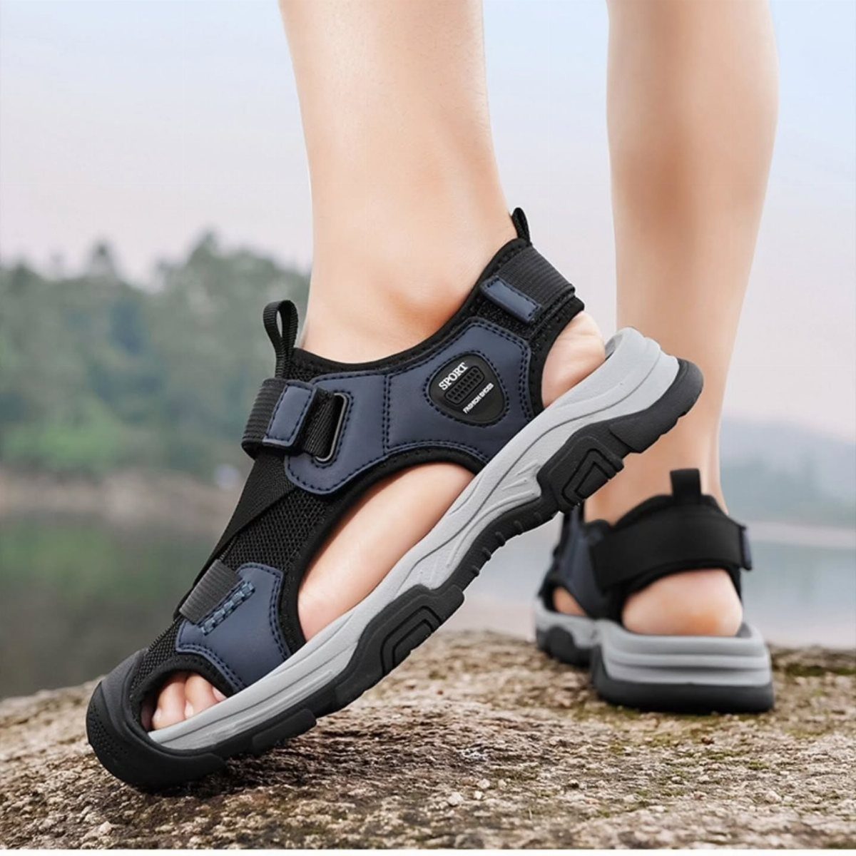 Black and grey sport sandals with thick soles worn on a person's feet.