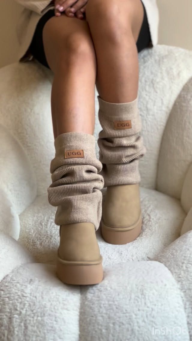 Tan suede platform boots paired with cream ribbed knit leg warmers on a person's legs.